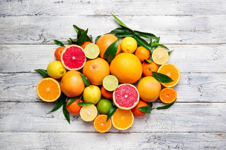 新鲜柑橘类水果背景。橙, 葡萄柚, 柠檬, 石灰, 橘子。将柑橘类水果与树叶混合