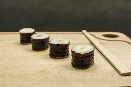木制木板上的筷子和 hosomaki