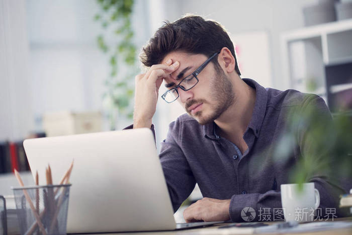 年轻人在电脑上工作头痛