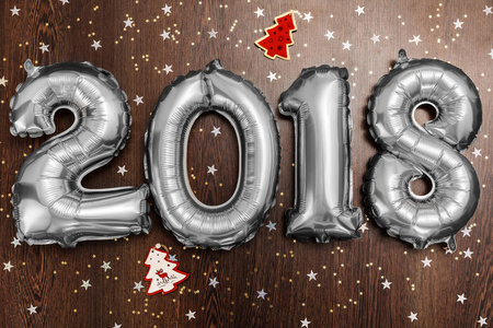 明亮的金属银色气球图 2018, 圣诞节, 新年气球与亮闪闪的星在黑暗的木桌背景