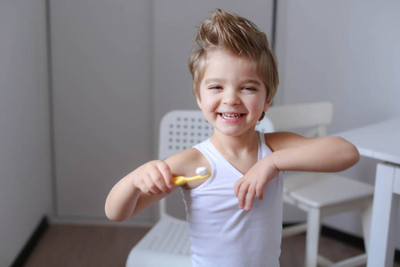 快乐有趣的小男孩拿着牙刷和刷牙的画像