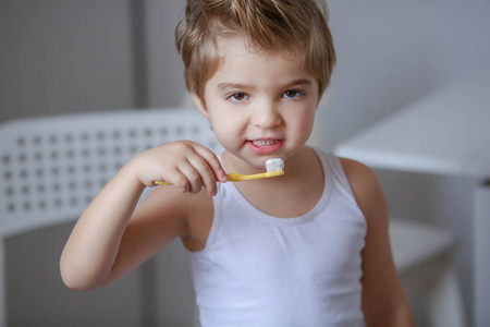 滑稽的小男孩拿着牙刷和刷牙的画像