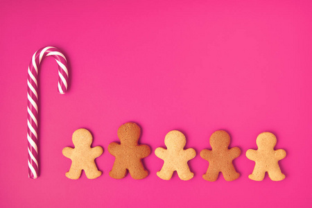 姜饼人圣诞节背景。在粉红色的背景与糖果