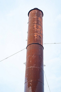 废弃的生锈工业烟囱，白色背景上有一些旧油漆