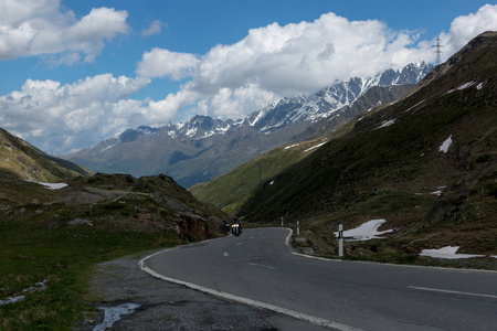 危险的全景蛇形公路高在阿尔卑斯山融化的雪之间