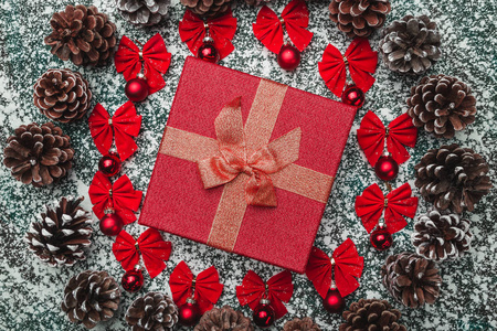 上面的顶部视图，从上面的圣诞礼物盒，在一个圆圈内，由红色蝴蝶结，常绿玩具和松树在灰色大理石背景问候。