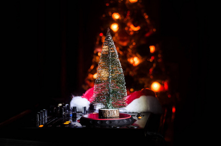 Dj 混合器与耳机在黑暗的夜总会背景与圣诞树新年前夕。在 Dj 桌上关闭新年元素或符号 圣诞老人雪人狗2018礼品盒 