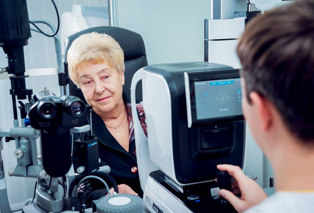 高级妇女与眼科医生检查她的视力。 医疗设备。 核心测量。