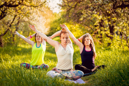 三个女孩在公园练习瑜伽