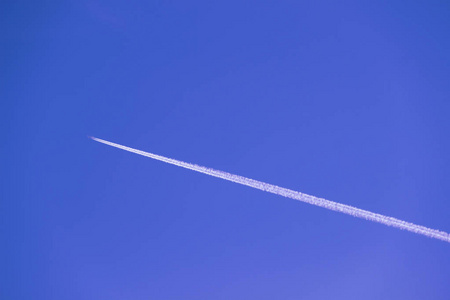 对角线飞机在晴朗的蓝天上的痕迹