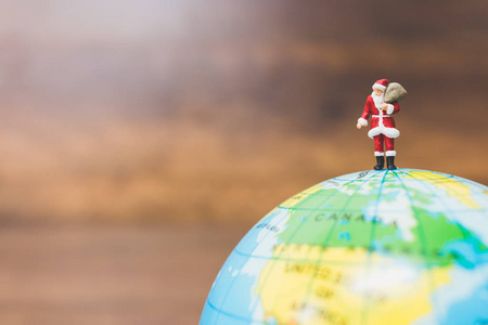 微型地球微型人物 圣诞老人在地球上进行照片