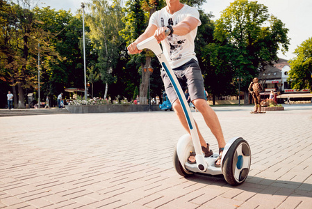 年轻的白种人骑在城市公园的塞格威