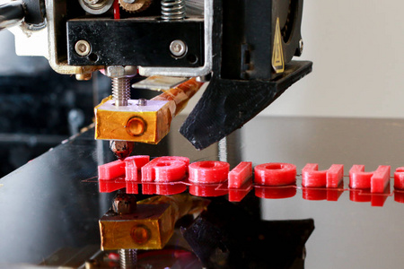 3D打印机打印单词3D技术的红色字母关闭。