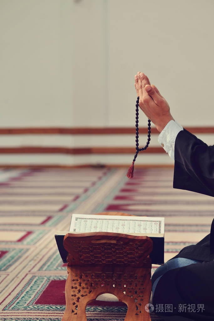 回教人民的手祈祷与清真寺内部背景