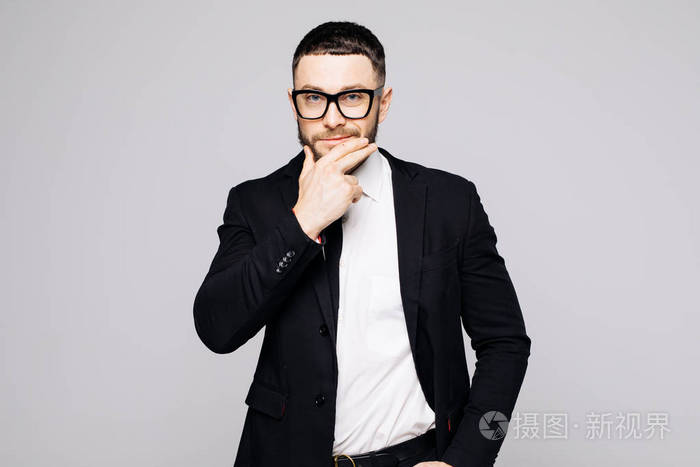 黑色西装,领带摸下巴,灰色背景下的严肃时髦帅气男子肖像