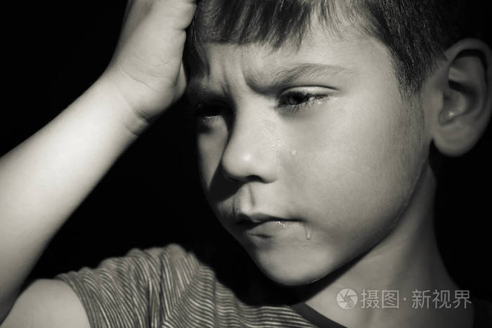 小悲伤的男孩在黑色背景下哭泣虐待儿童概念