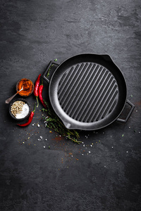 空铸铁烧烤锅与配料烹饪黑色背景顶部视图