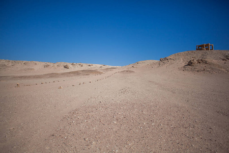 蓝天背景下沙漠中有石块的未铺路