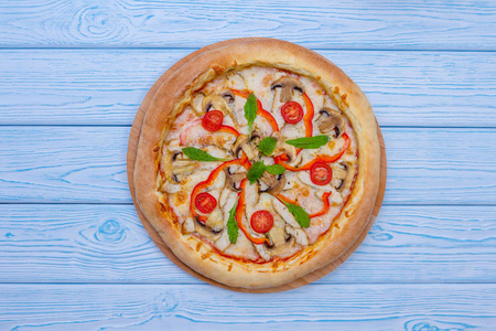 自制披萨配西红柿从顶部与浅蓝色木桌的看法