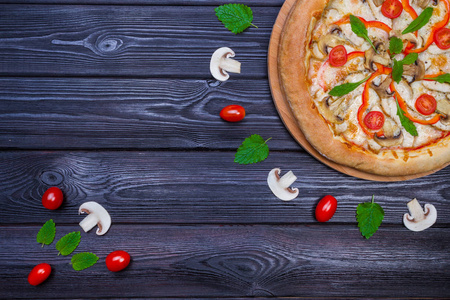 自制披萨配西红柿黑木桌上看