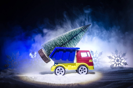 带枞树的微型车在白雪皑皑的冬天阿马特福雷斯, 或运载一棵圣诞树的玩具车和在夜时间