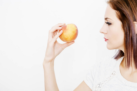 女孩拿着桃子。 年轻的女人手里拿着桃子。 水果和蔬菜在他们手中。 多种维生素