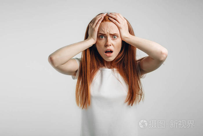 红头发的女孩在白色背景强的表示恐惧圆的眼睛