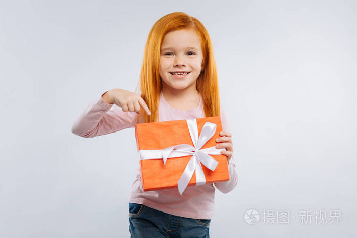 高兴的孩子指着她的礼物