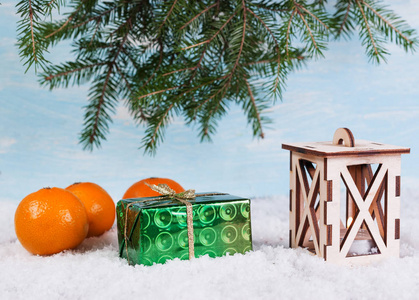 雪上的灯笼绿盒子和橘子