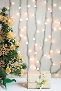 一棵圣诞树装饰的雪花和一个花环与礼品盒的背景下的散和白色板。圣诞快乐, 冬季假期明信片的想法