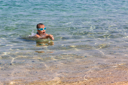 年轻的旅游女孩游泳运动眼镜是漂浮在爱琴海的 Sithonia 半岛海岸