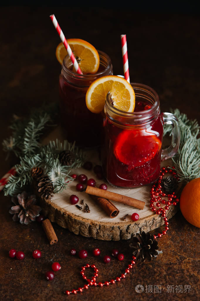 圣诞蔓越莓饮料柠檬和吸管肉桂冷杉枝和珠子装饰