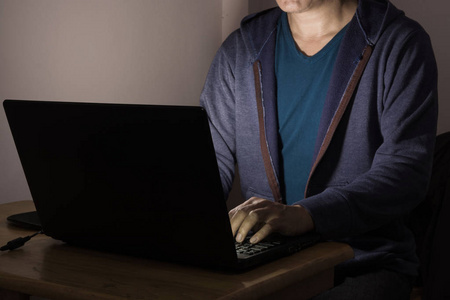 在黑暗中工作或玩笔记本电脑的男性或男性照片