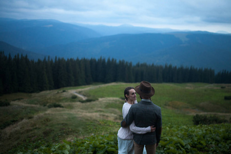 新娘和新郎站在山的背景上拥抱