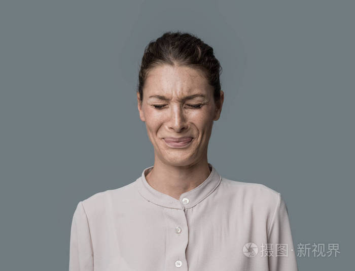 令人厌恶的失望的女人皱着眉头,看着镜头