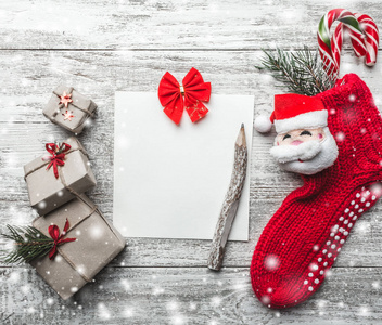 圣诞激励主题的记事本和老式铅笔与空间的文字装饰红色蝴蝶结，杉木，圣诞袜在木制背景视图从上面的贺卡。