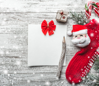 圣诞激励主题的记事本和老式铅笔与文字装饰空间红色蝴蝶结，杉木，圣诞袜礼物盒在木制背景视图从上面的贺卡。