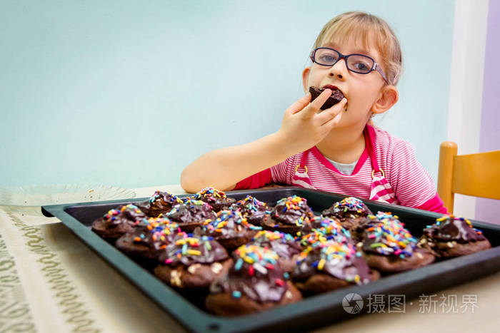 可爱的小孩子的肖像吃蛋糕装饰松饼