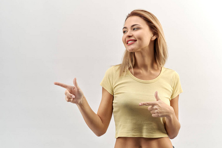 微笑的年轻女子女孩在一个短暂的淡黄色 tshirt 寻找