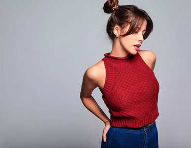 一幅美丽可爱的深褐色的女模特穿着休闲的夏红色毛衣,没有化妆,头发是