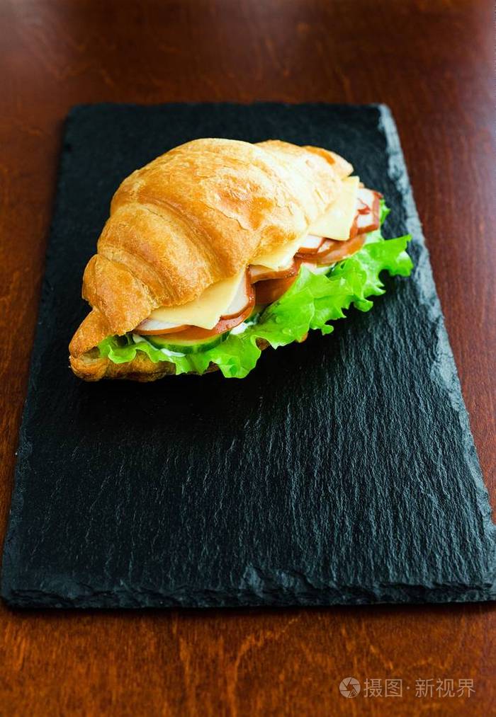 近距离观看美味的牛角面包三明治和奶酪和火腿