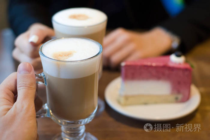 两杯拿铁咖啡带泡沫和蛋糕的女人和男人