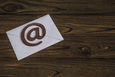 邮件信封上的电子邮件符号。 在树的纹理上。 设计地点