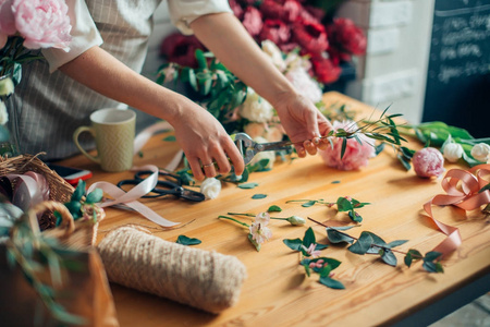 在工作的花店 漂亮的年轻金发女人制作不同花花束