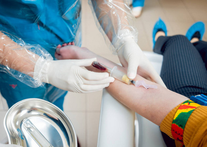 s hands taking a blood sample.