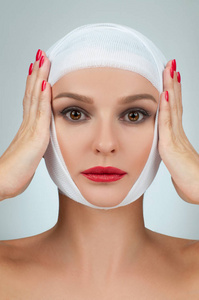 医美脸部漂亮女人整容后用绷带包扎脸部.美容,时尚和整形外科概念照片