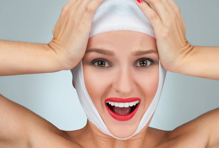 脸部衰老漂亮女人整容后用绷带包扎脸部.美容,时尚和整形外科概念照片