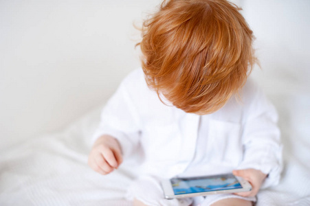 红发男孩看着手机玩游戏图片