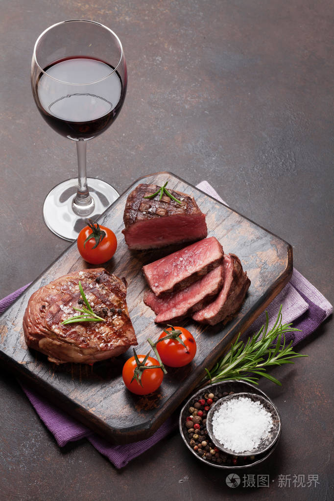 砧板上的烤片牛排和一杯红酒