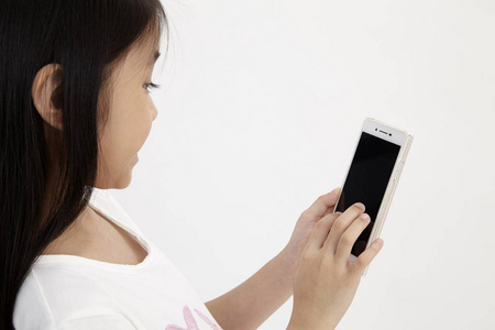 可爱的小女孩用智能手机.孤立在白色上.照片